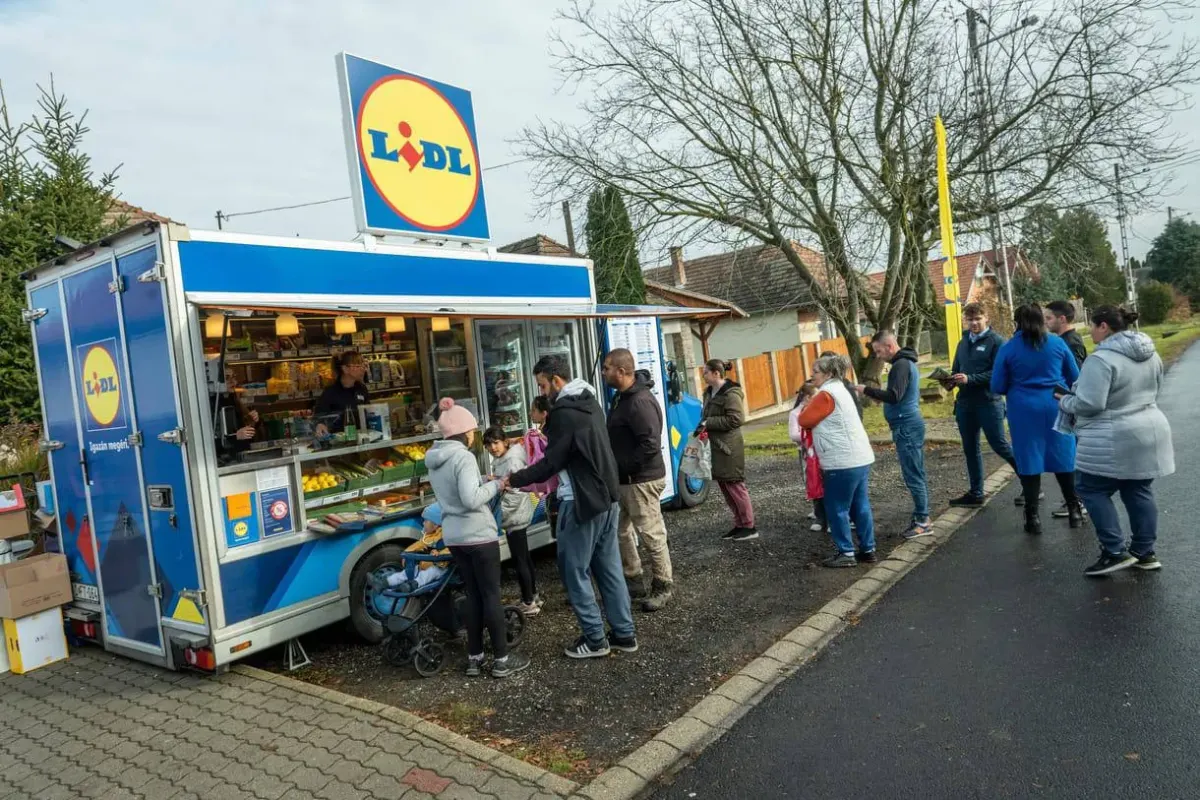 People queueing at a Lidl mobile shop van on a residential street People queueing at a Lidl mobile shop van on a residential street